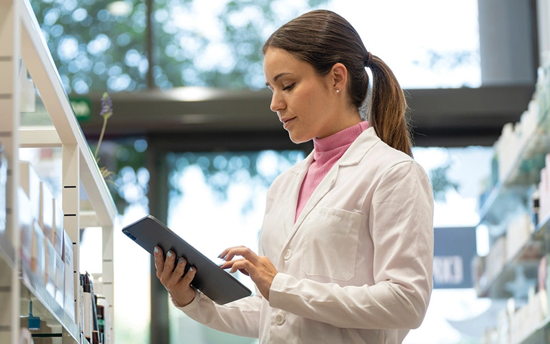 A student checking the B. Pharmacy syllabus on a tablet