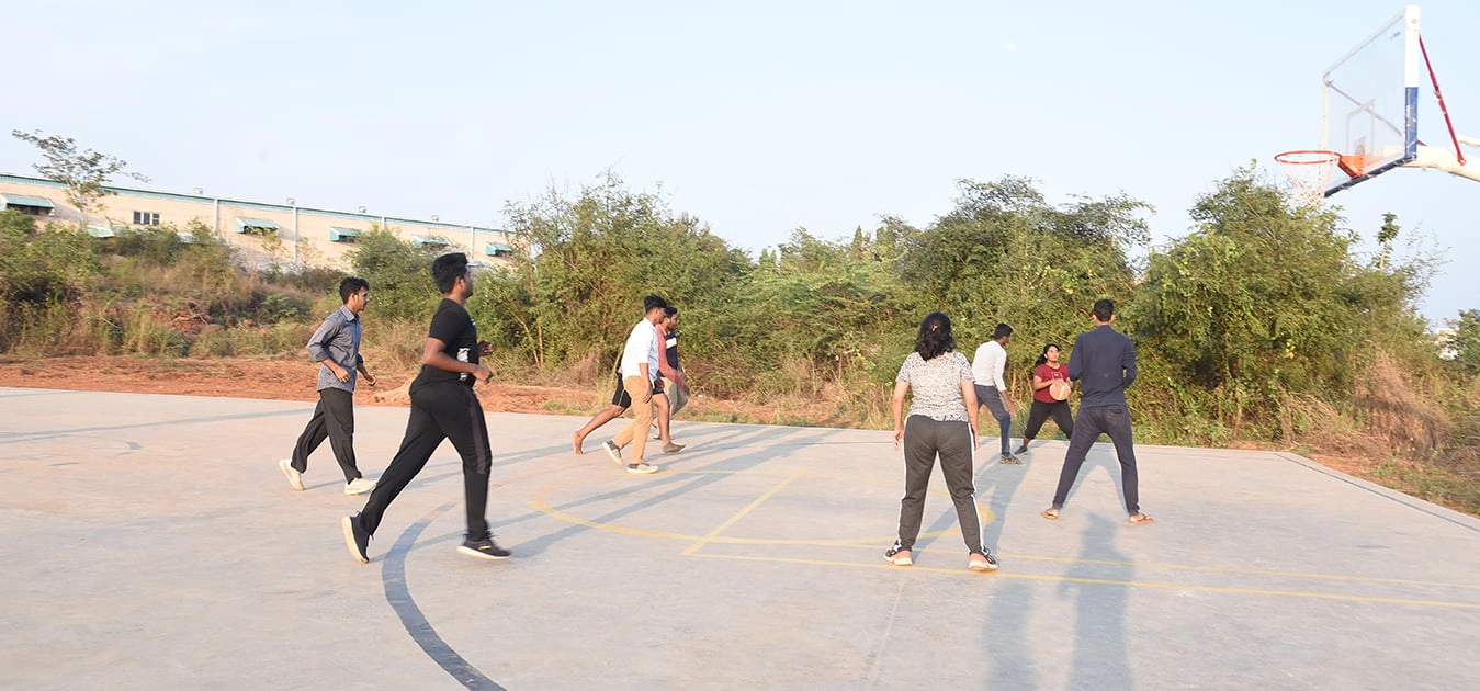 Students engaged in a basketball game on the outdoor Apollo University court