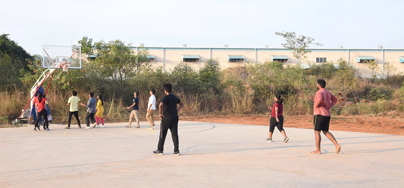 Outdoor sports field at Apollo University—basketball court visible alongside shot put area