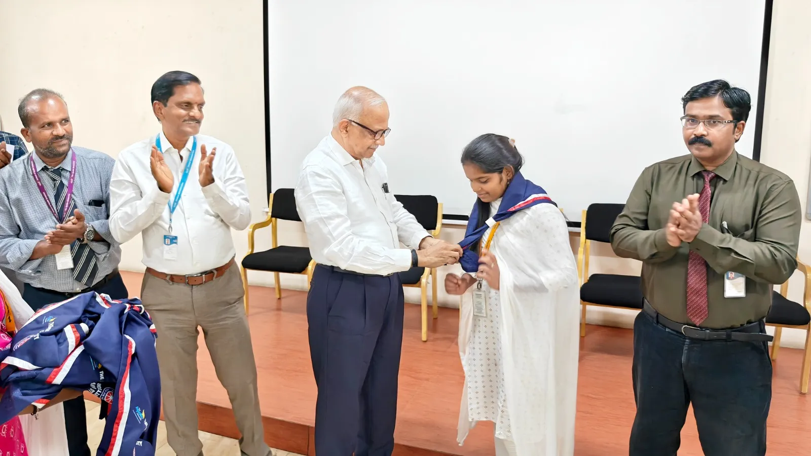 Vice-Chancellor Dr. H. Vinod Bhat presents an NSS scarf to a student at The Apollo University.