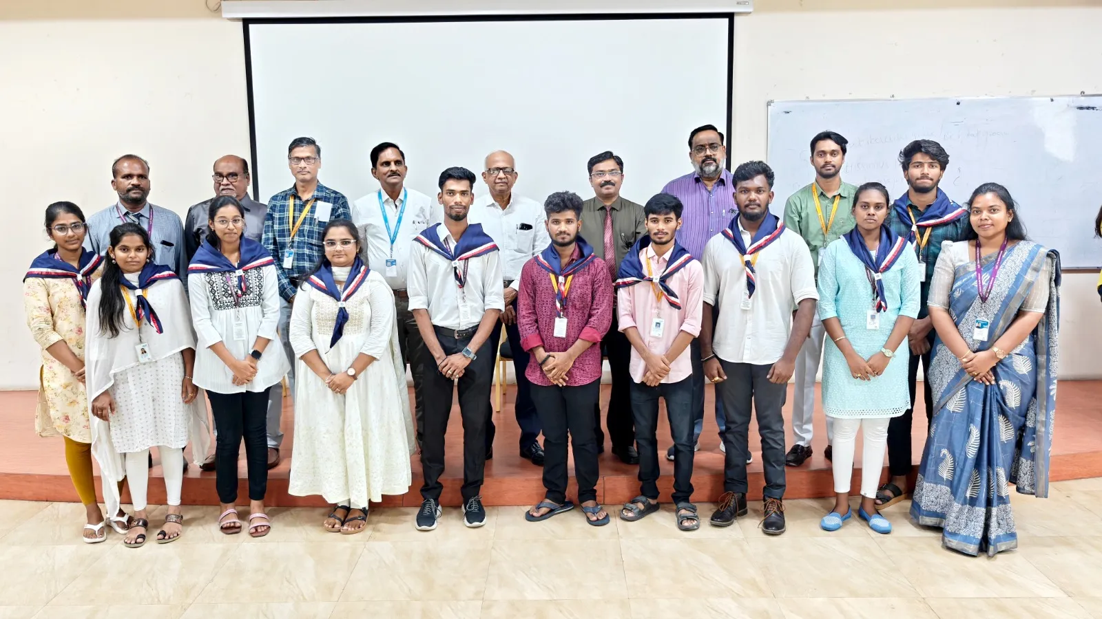 Group photo of NSS volunteers with faculty after scarf distribution at The Apollo University event.