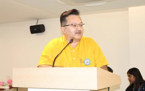 Dr. Kiran Acharya speaking on stage at The Apollo University event