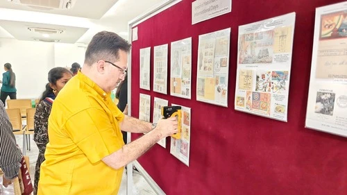 Dr. Kiran Acharya reviewing display panels at Apollo University event.