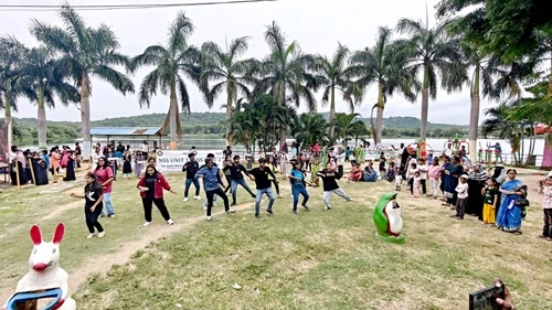 Students gather in a large open lawn for a flash mob performance at Apollo University