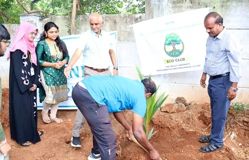 Students and Prof. M. Potharaju engaged in hands-on tree plantation drive on university campus.