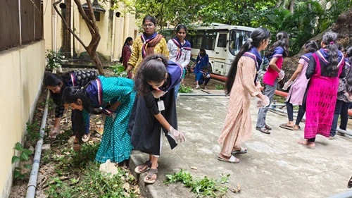 Volunteers cleaning outdoor areas of district hospital for awareness