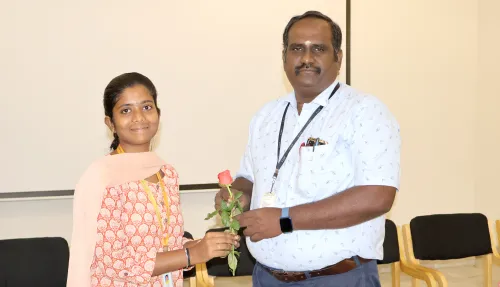 Prof. S. Prem Kumar presenting a flower to a student